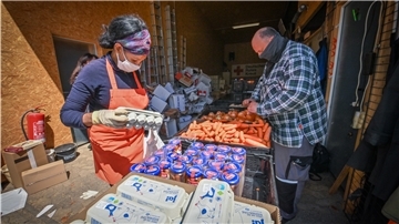 Helfer der Tafel und des DRK kümmern sich um das Packen und Verteilen der Essenspakete für bedürftige Kinder.