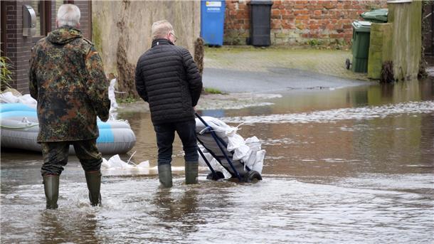 Helfer transportieren Sandsäcke, um die Verdener Innenstadt im Dezember 2023 vor dem Aller-Hochwasser zu schützen.