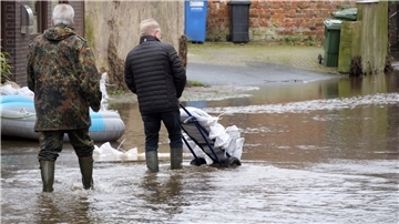 Helfer transportieren Sandsäcke, um die Verdener Innenstadt im Dezember 2023 vor dem Aller-Hochwasser zu schützen.
