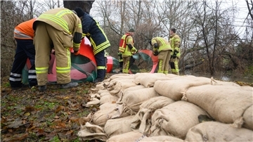 Helfer von der Feuerwehr und Technischem Hilfswerk (THW) installieren ein mobiles Hochwasserschutzsystem. 
