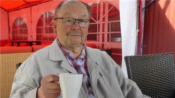 Ein älterer Mann mit einer Kaffeetasse.