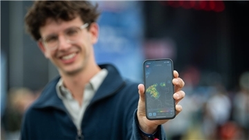Ein Mann hält ein Smartphone in die Kamera