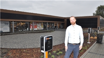 Hendrik Lenz, Inhaber des Wohncenters, vor einigen von insgesamt 20 geplanten Ladesäulen für Elektroautos rund um seinen Parkplatz.