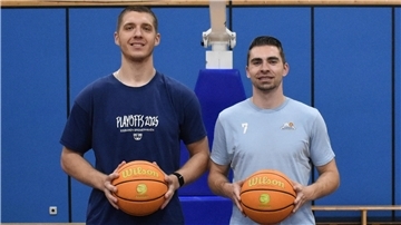 Zwei Spieler der Eisbären Bremerhaven halten einen Basketball in der Hand. 