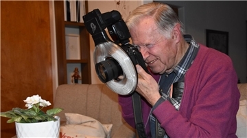 Das Foto zeigt Hermann Gehlken beim Fotografieren einer weißen Blume. 