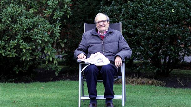 Ein Mann sitzt in einem Stuhl.