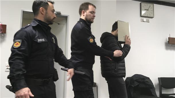 Der Angeklagte wird von Justizbeamten in den Gerichtssaal geführt.