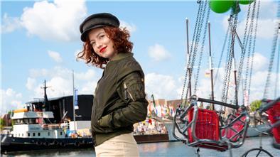 Junge Frau vor der Kulisse des Neuen Hafens und der Havenwelten in Bremerhaven