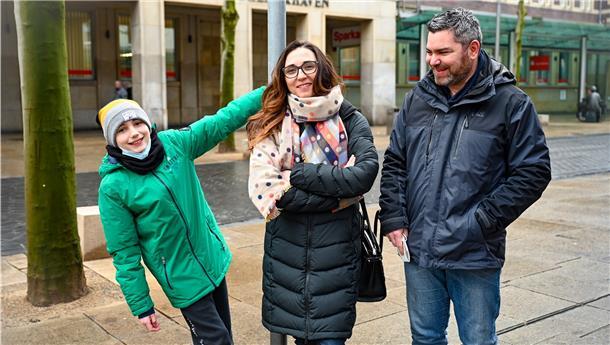 Hier, mitten auf der „Bürger“, nimmt die Auswanderergeschichte von Cynthia Andraczek ihren Anfang. Ohne das deutsche Praktikum bei der Sparkasse vor 20 Jahren hätte die Französin nicht ihren späteren Mann Martin kennengelernt. Seinetwegen verließ sie ihre Heimat. Sohn Dorian wächst mit beiden Staatsbürgerschaften auf.