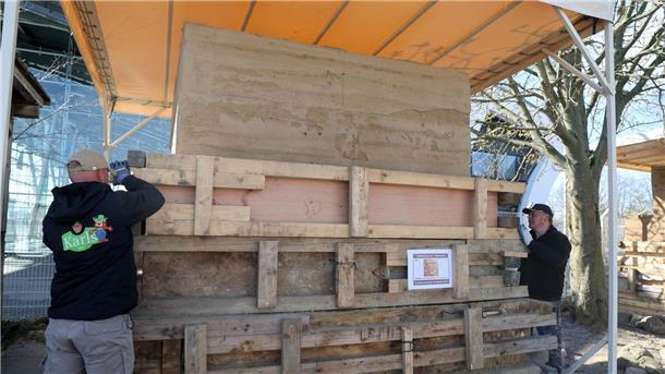 Hinter den Holzplanken steckt ein Sandblock. Der wird jetzt in eine Märchenform geschnitzt.