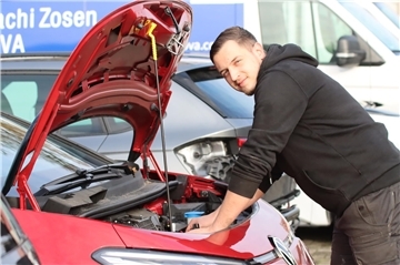 Ein Mann steht an einem Auto.
