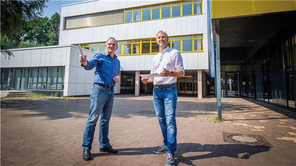 Holger Schneeberg, Technischer Betriebsleiter bei Seestadt-Immobilien (rechts) und Architekt Nico Dohm vor der neuen Energiespar-Fassade der Berufsschule für Technik am Schulzentrum Carl von Ossietzky.
