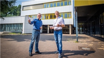 Holger Schneeberg, Technischer Betriebsleiter bei Seestadt-Immobilien (rechts) und Architekt Nico Dohm vor der neuen Energiespar-Fassade der Berufsschule für Technik am Schulzentrum Carl von Ossietzky.
