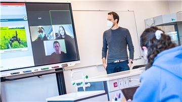 Hybridunterricht im Klassenzimmer in der gymnasialen Oberstufe am Schulzentrum Geschwister Scholl. Chemie- und Biologielehrer Moritz Krause entwickelt mit seinen Schülern eine Zeitung zum Thema alternative Treibstoffe. Die Schüler arbeiten digital an Tablets und tauschen sich über Distanz miteinander aus.