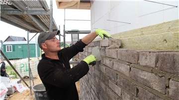 Igor Alcedarevschi mauert eine Fassade.