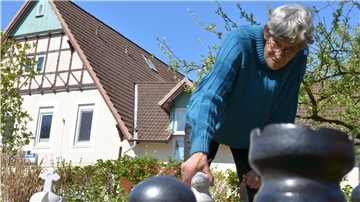 Ihr Großvater ist nach Bremerhaven eingewandert, um Arbeit zu finden. Brigitte Böhm in ihrem Garten. Die Schachfiguren hat sie selbst gemacht. Foto: Philipp Overschmidt