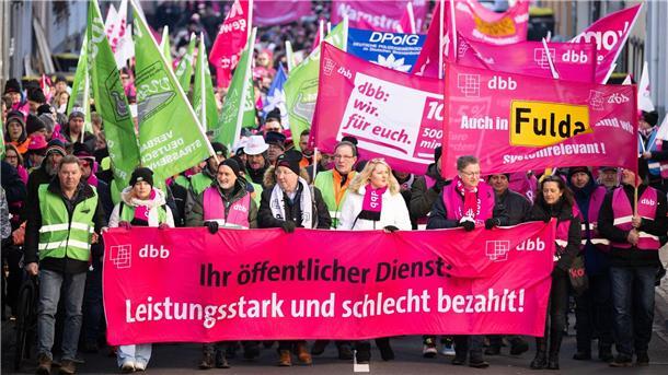 „Ihr öffentlicher Dienst: Leistungsstark und schlecht bezahlt“ steht bei einem Warnstreik von Beschäftigten im öffentlichen Dienst in Fulda auf einem Banner.