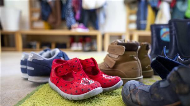 Schuhe stehen in der Garderobe eines Kindergartens.
