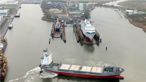 Schiff vor den Schwimmdocks einer Werft.