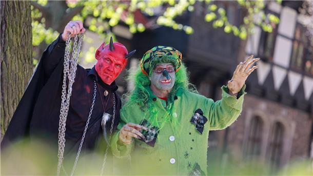 Hexen und Teufel feiern Walpurgisnacht im Harz Im Hexen- und Teufelskostüm stehen zwei Walpurgis-Besucher in Wernigerode vor der Erstürmung des Rathauses im Stadtzentrum.