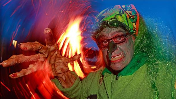 Hexen und Teufel feiern Walpurgisnacht im Harz Im Hexenkostüm steht ein Besucher des Walpurgisfestes in Schierke am Feuer.