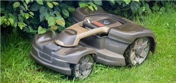Ein Mähroboter mäht Gras in einem Garten. Im „Mähfreien Mai“ bleibt der Rasen wild – zur Freude von Bienen und Blumen.