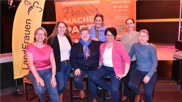 Frauen vor einem Werbebanner.