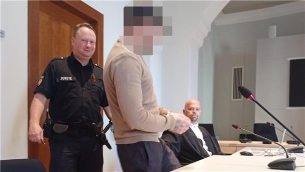 Angeklagter wird von Justizbeamten in den Saal geführt.
