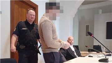Angeklagter wird von Justizbeamten in den Saal geführt.