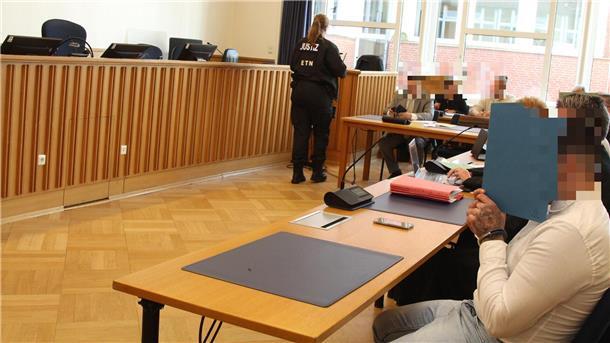 Die Angeklagten verbergen ihr Gesicht hinter Pappdeckeln