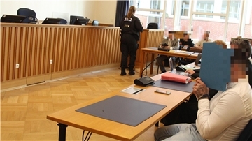 Die Angeklagten verbergen ihr Gesicht hinter Pappdeckeln