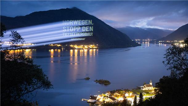Lichtprojektion auf die Seite eines Bergs: "Norwegen, stopp den Tiefseebergbau – Greenpeace"