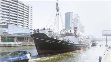 Schiff vor Häuserkulisse. 