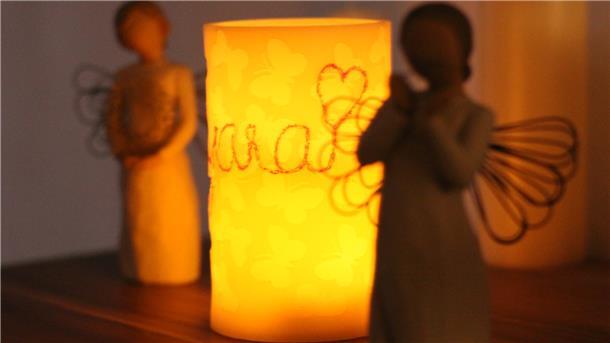Im Wohnzimmer von Insa und Sascha leuchtet jeden Abend die Kerze mit dem Namen ihrer verstorbenen Tochter. Ein Ritual, das den Eltern lieb und wichtig ist.