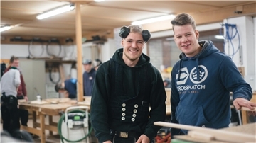 Das Foto zeigt zwei junge Zimmerleute. 