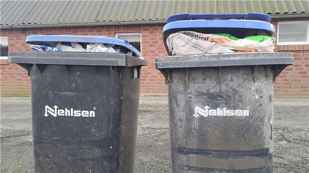 Vollgestopfte Mülltonnen stehen vor einem Gebäude. Viele Mülltonnen im Landkreis Cuxhaven sind während des Streiks der Nehlsen-Mitarbeiter nicht geleert worden. 
