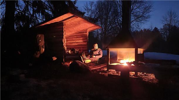 Immer wieder kann Alec Kempendorf auch in kleinen Holzhüten übernachten. Und den Abend nach der gemeisterten Radstrecke am Lagerfeuer genießen.