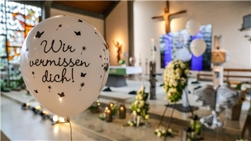 In Absprache mit Arians Angehörigen, so teilte die Kirche mit, hatten ein Bestattungsinstitut und Freunde der Familie die St. Michael Kirche unter anderem mit Blumenkränzen, Fotos des Elmer Jungen und Luftballons geschmückt.