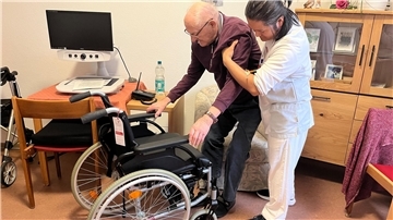 Eine Pflegekraft unterstützt einen Bewohner in einem Pflegeheim.