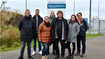 In der Bildmitte stehen Susanne Mrugalla, GP Joule Projektentwickler M.A. Gunnar Lux, Ingolf Lienau, umgeben von weiteren GP Joule-Mitarbeiterinnen und Mitarbeitern.