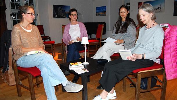 Vier Frauen sitzen auf Stühlen.