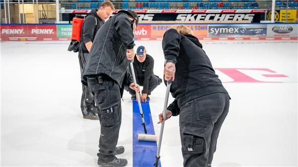In der Eisarena werden die Markierungen und Werbungen jetzt geklebt. Die Angestellten der Stadthalle um Eric Wester, Julian Garchel, Samir Choueiki und Paula Plümper sind in den vergangenen Tagen bereits fleißig gewesen.
