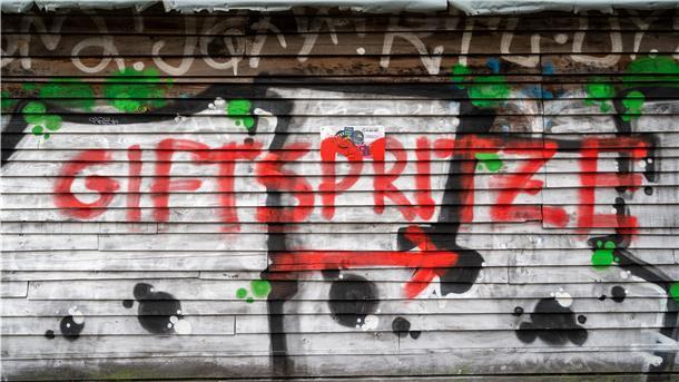 In der Nähe eines Impfzentrums für die Impfung gegen das Coronavirus ist ein Graffiti mit dem Schriftzug „Giftspritze".