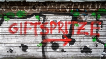 In der Nähe eines Impfzentrums für die Impfung gegen das Coronavirus ist ein Graffiti mit dem Schriftzug „Giftspritze".