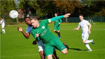 zwei Fußballer kämpfen um den Ball.