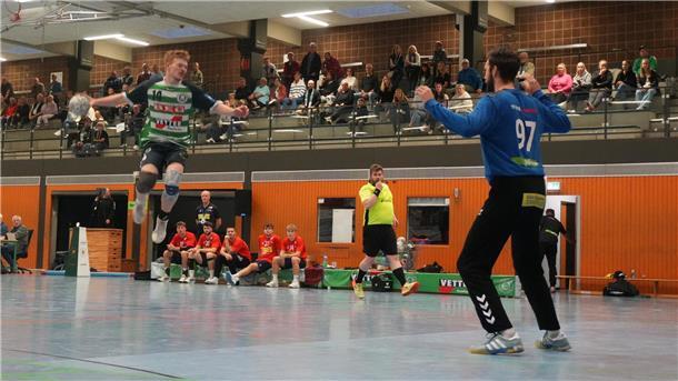 Ein Handballer mit einem Ball in der Hand im Sprung zum Torwurf.