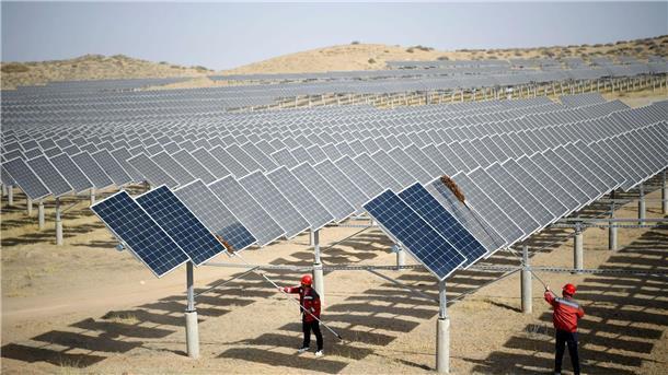 In einem Photovoltaik-Kraftwerk in Yinchuan, im nordwestchinesischen Autonomen Gebiet Ningxia Hui, stauben Mitarbeiter nach windigem Wetter Photovoltaik-Paneele ab.