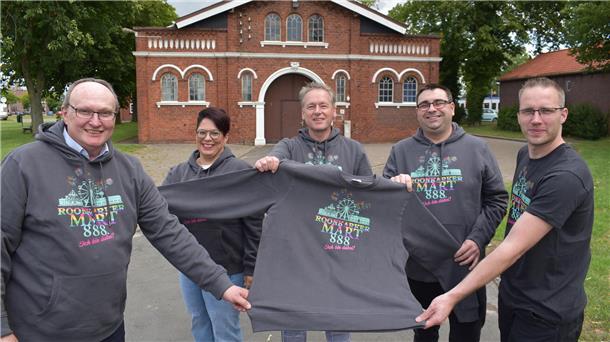 In Event-Kleidungsstücken zeigen sie ein Event-Sweatshirt (von links): Bürgermeister Harald Stindt, Marktmeisterin Christiane Hagen, Mario Glasner (Sprecher der Schlaganfall-Selbsthilfegruppe Rodenkirchen), Unternehmer Patrick Grimm und Michael Logemann.
