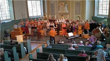 In farbenfrohen Gewändern zogen Sängerinnen und Sänger der „Joyful voices“ während des Trommel-Intros ein, um anschließend in die Bitte „Peace to the world“ einzustimmen.