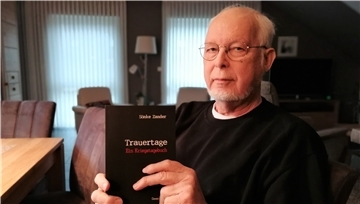 Sönke Zander hält sein neues Buch in die Kamera.